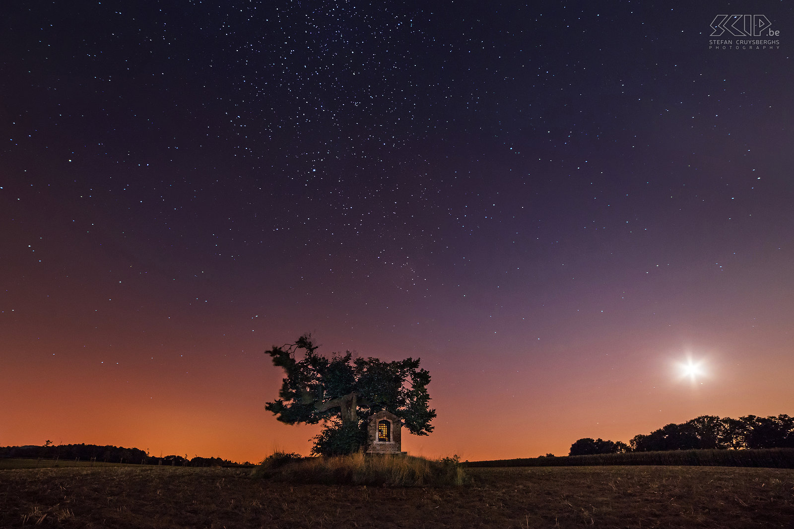 Sint-Pieters-Rode - Bright stars at the chapel of Horst The castle and the chapel of Horst are photogenic landmarks near my new home. So in recent months I went out to photograph them several times, mostly in the evening and at night or when there were special weather conditions. I tried to create some unique photos of these monuments that differ from the images that already have been captured by many other people.<br />
 <br />
The small chapel of Saint Joseph is located in a field under an old linden tree nearby the castle. It has been built in the beginning of the 19th century. On a clear night a lot of stars are visible. The orange glow on the horizon is the typical light pollution in our country. The bright light is the crescent moon. Stefan Cruysberghs